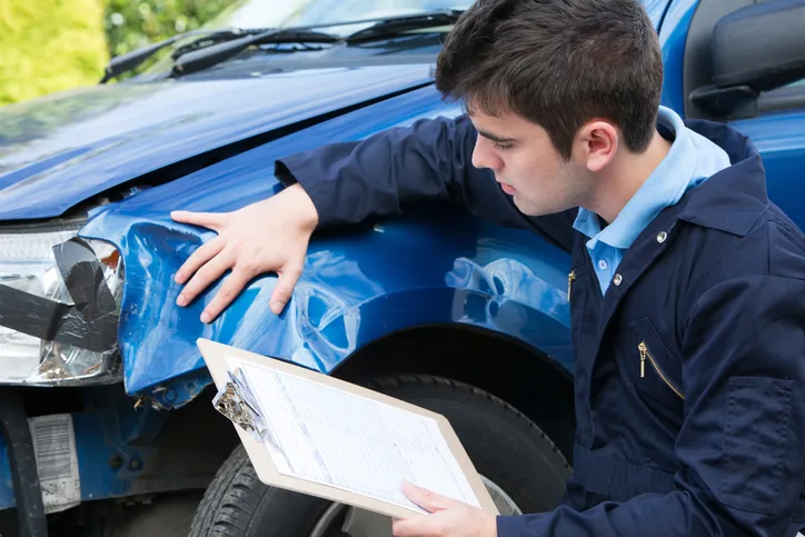 Car body repair technician inspecting damage in Barnstaple Devon